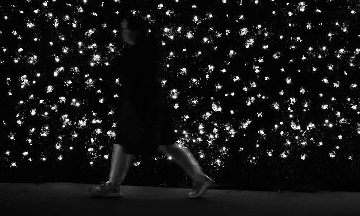 A woman passes through a sparkled backdrop.