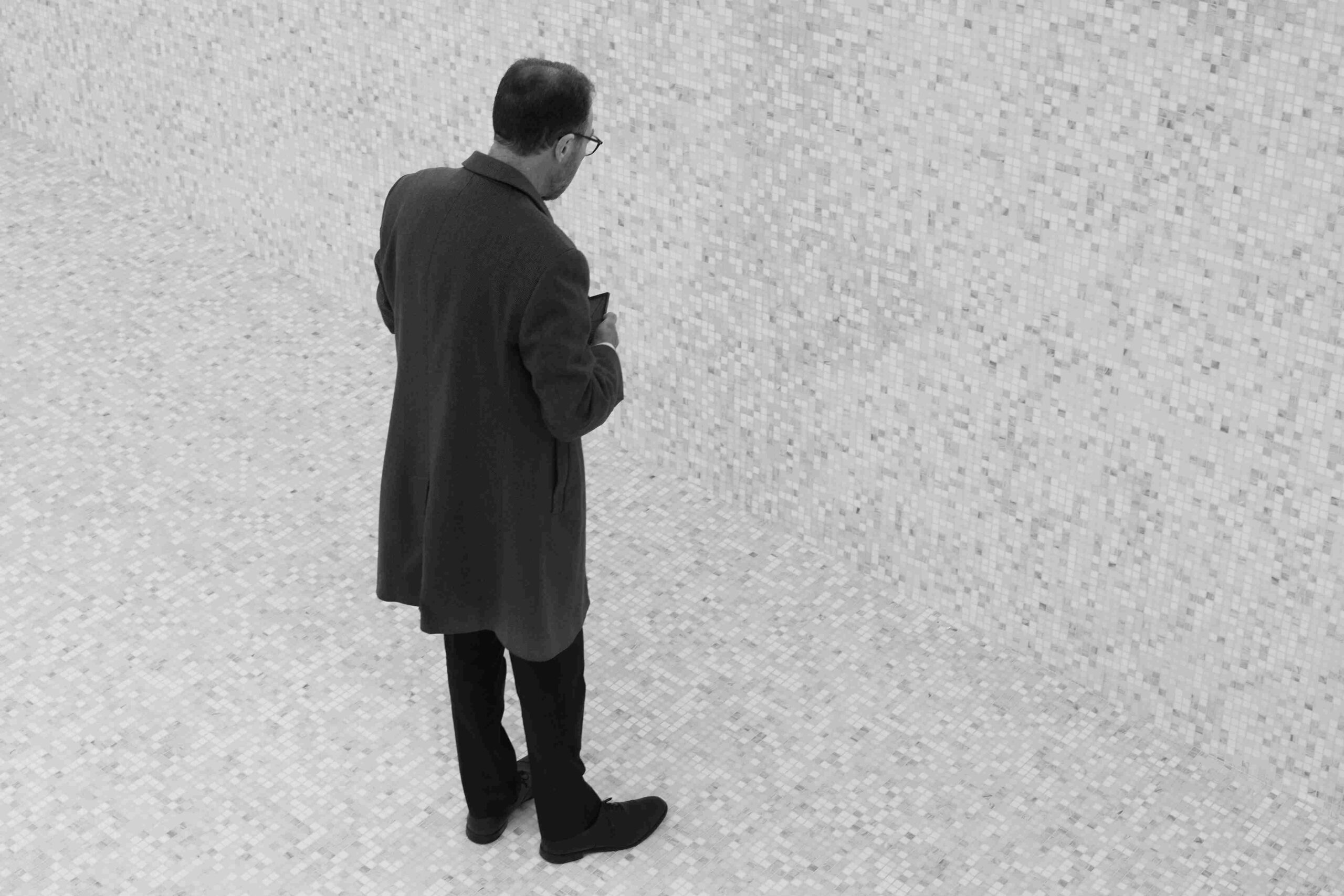 A man stands solo in a geometric tiled landscape.